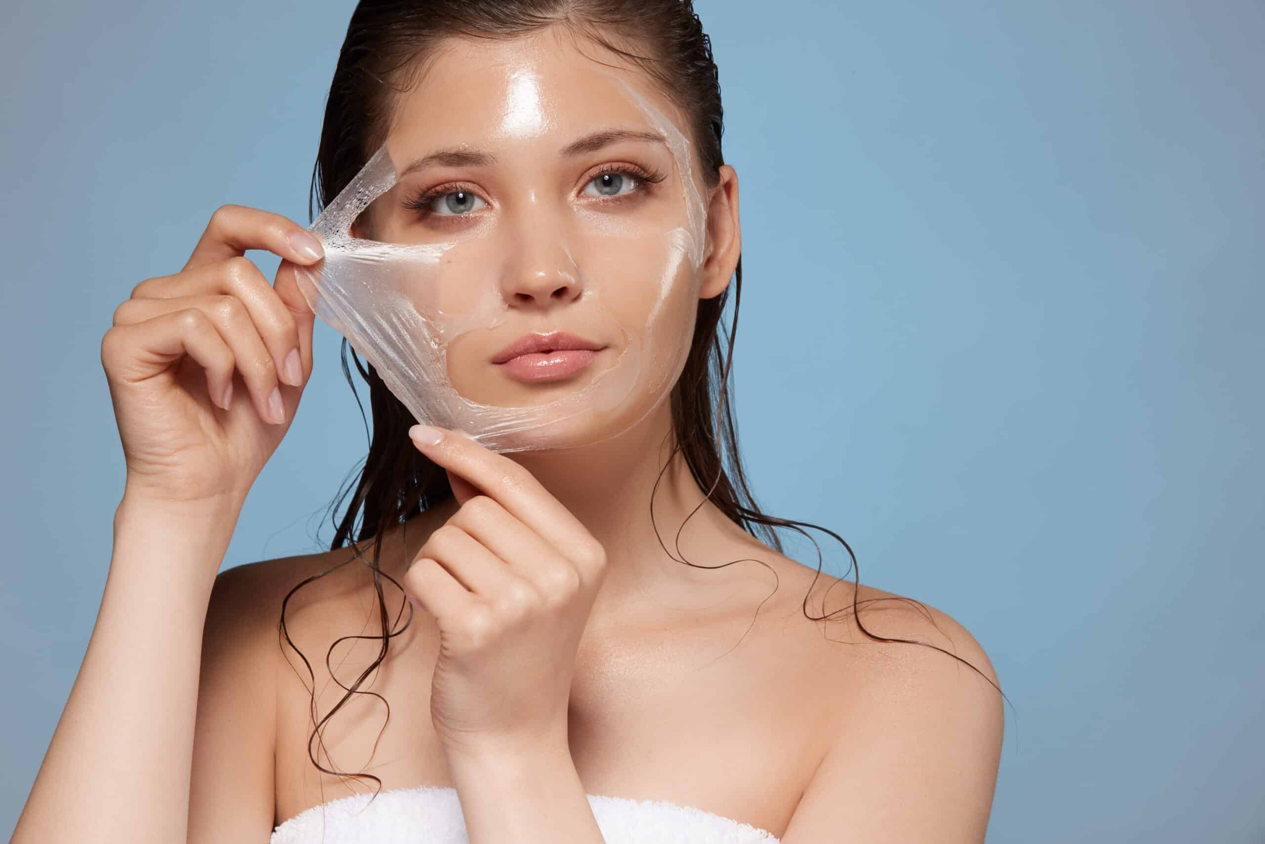 Woman peeling off a hydrating facial mask