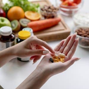 Woman professional nutritionist checking dietary supplements in hand